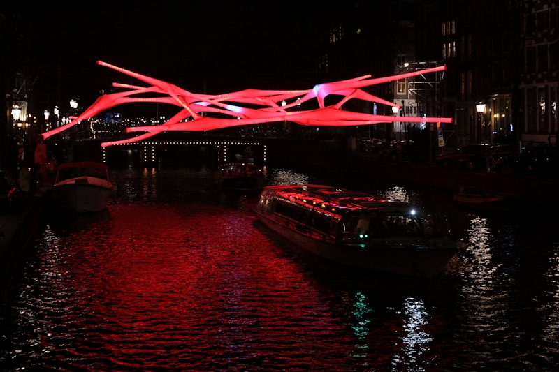 A boat floating down a river under a red light