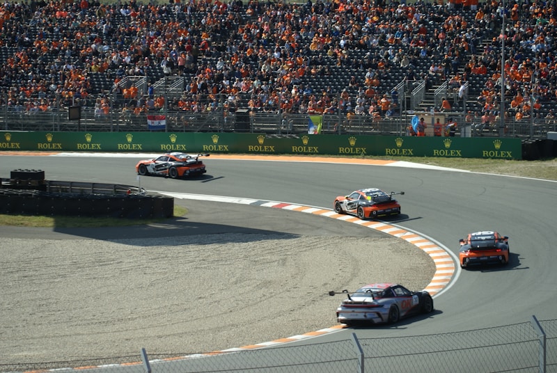 A group of race cars on a track with a crowd watching in Zandvoort's Dutch grand prix